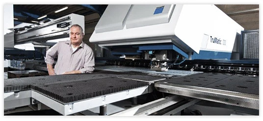 Mitarbeiter von Oberschmidt an der Stanz-Laser-Maschine TruMatic 7000 in der Fertigung